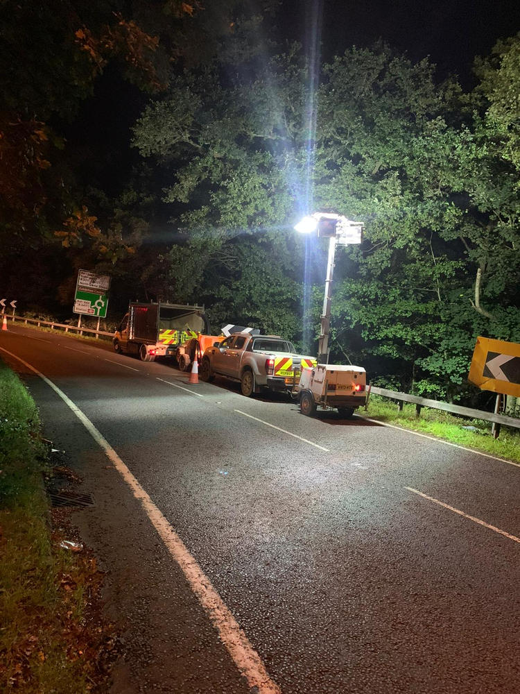 ADF working under a lighting tower on a closed road at night