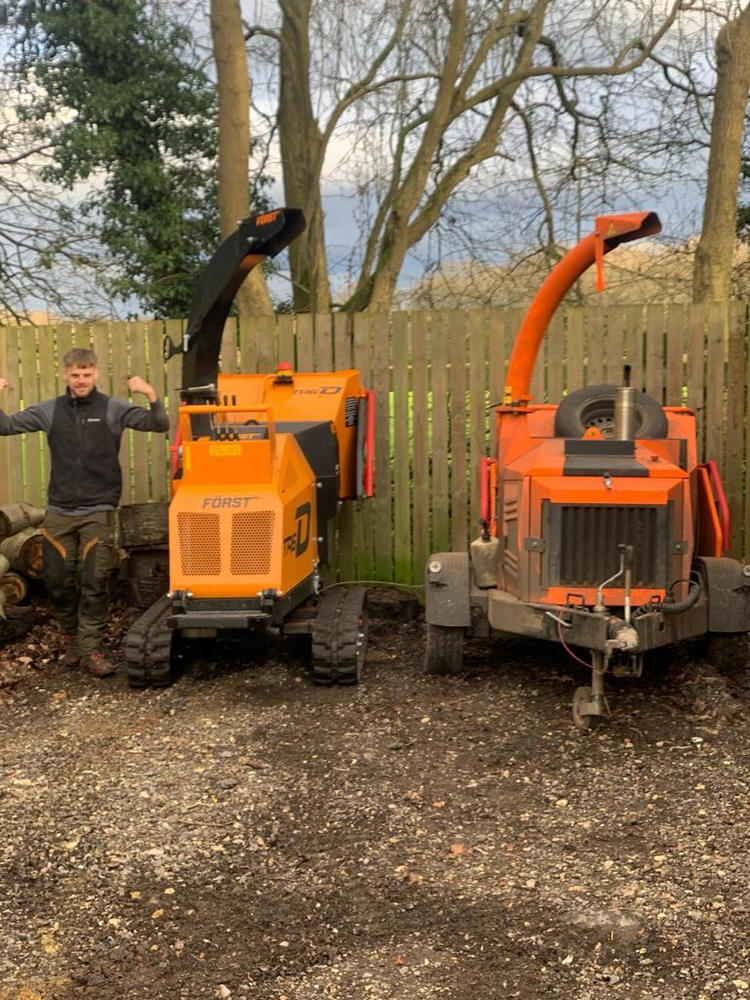 An ADF team member beside the two woodchippers at the yard